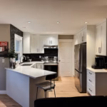 White shaker kitchen in Cloverdale Surrey with Dream White cabinets and Vicostone Polaris quartz peninsula.