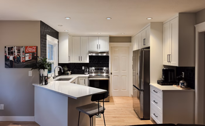 White shaker kitchen in Cloverdale Surrey with Dream White cabinets and Vicostone Polaris quartz peninsula.