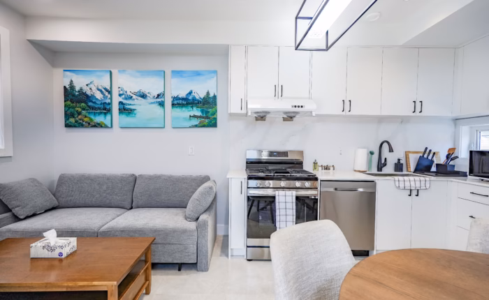 Open concept secondary suite kitchen with custom white cabinetry in West End New Westminster BC.