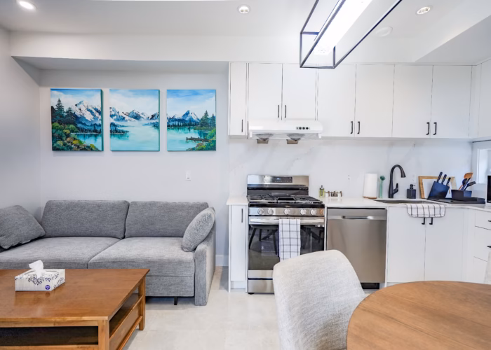 Open concept secondary suite kitchen with custom white cabinetry in West End New Westminster BC.