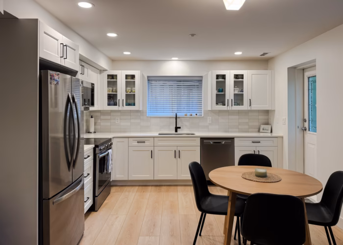 Dream White basement kitchen in Walnut Grove Langley with shaker cabinets, glass doors and dining area.