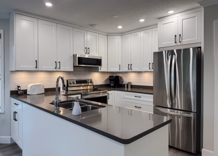 South Surrey kitchen with Dream White Shaker cabinets, peninsula sink and stainless steel appliances in Sunnyside Park.